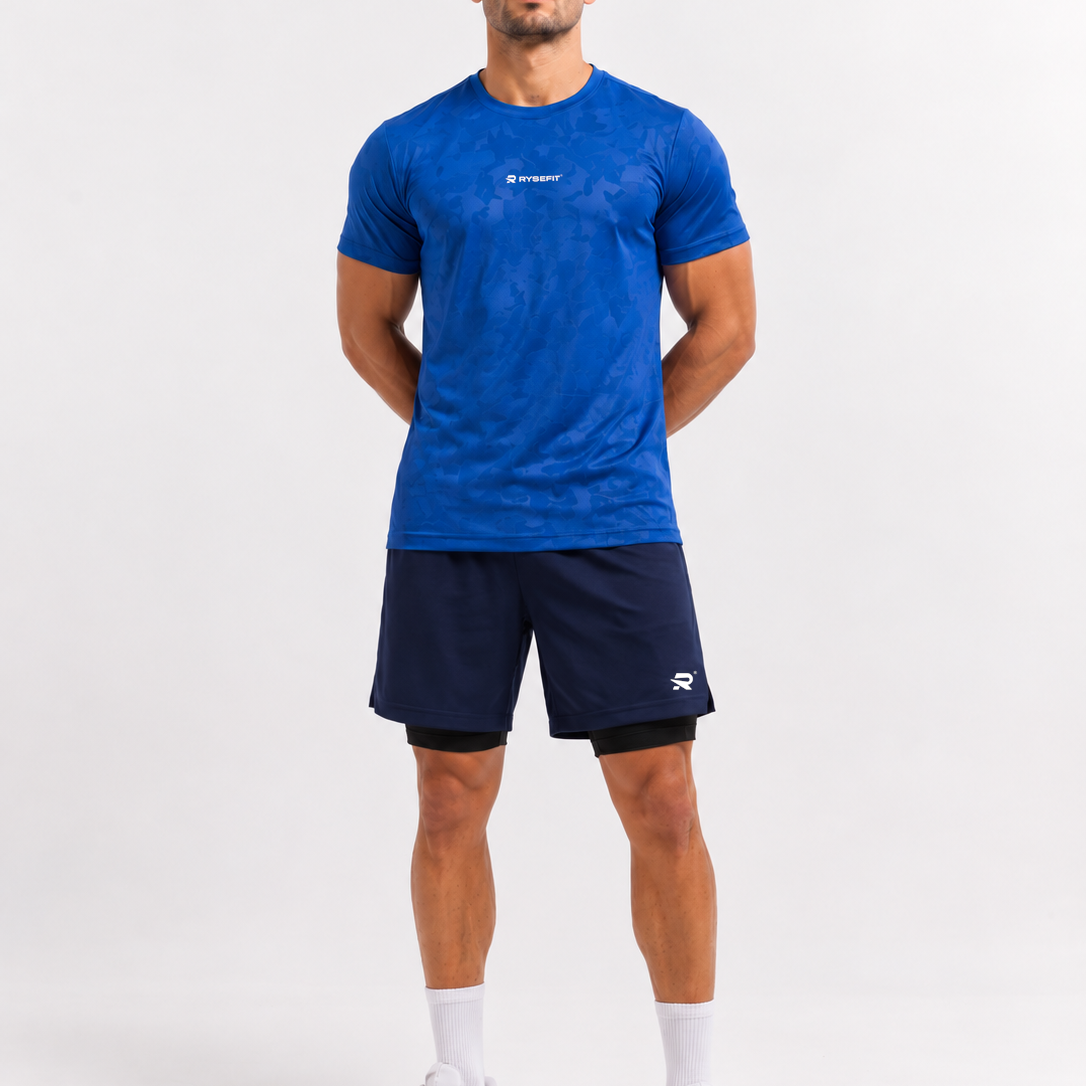 Rysefit Linha Stealth Azul: modelo de frente com camiseta camuflada azul e short azul-marinho