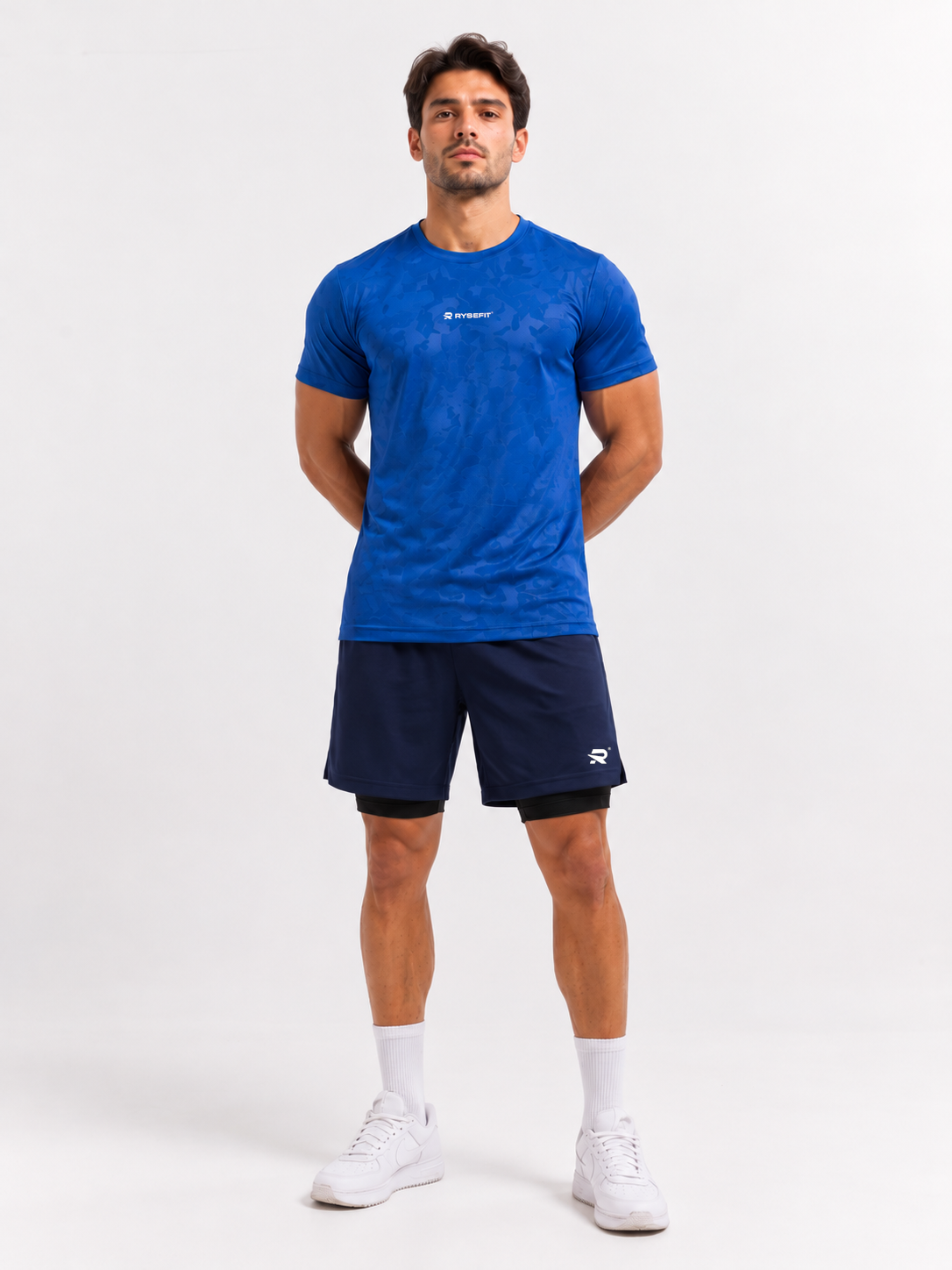 Rysefit Linha Stealth Azul: modelo de frente com camiseta camuflada azul e short azul-marinho